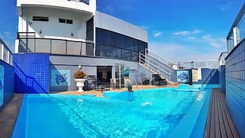 Una piscina al aire libre de temporada, sombrillas