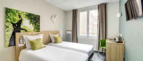 Une chambre d’hôtel avec deux lits, un bureau, une chaise, une fenêtre avec des rideaux et un téléviseur fixé au mur.