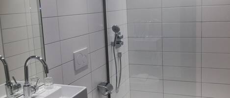 Un baño moderno con lavabo, inodoro y ducha.