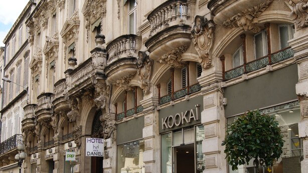 A historic building with ornate architectural details, a visible hotel sign, and a Kookai store. - Hôtel Danieli Avignon (Avignon)