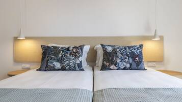 A double bed with a wooden headboard, two matching pillows, and a patterned bedspread.