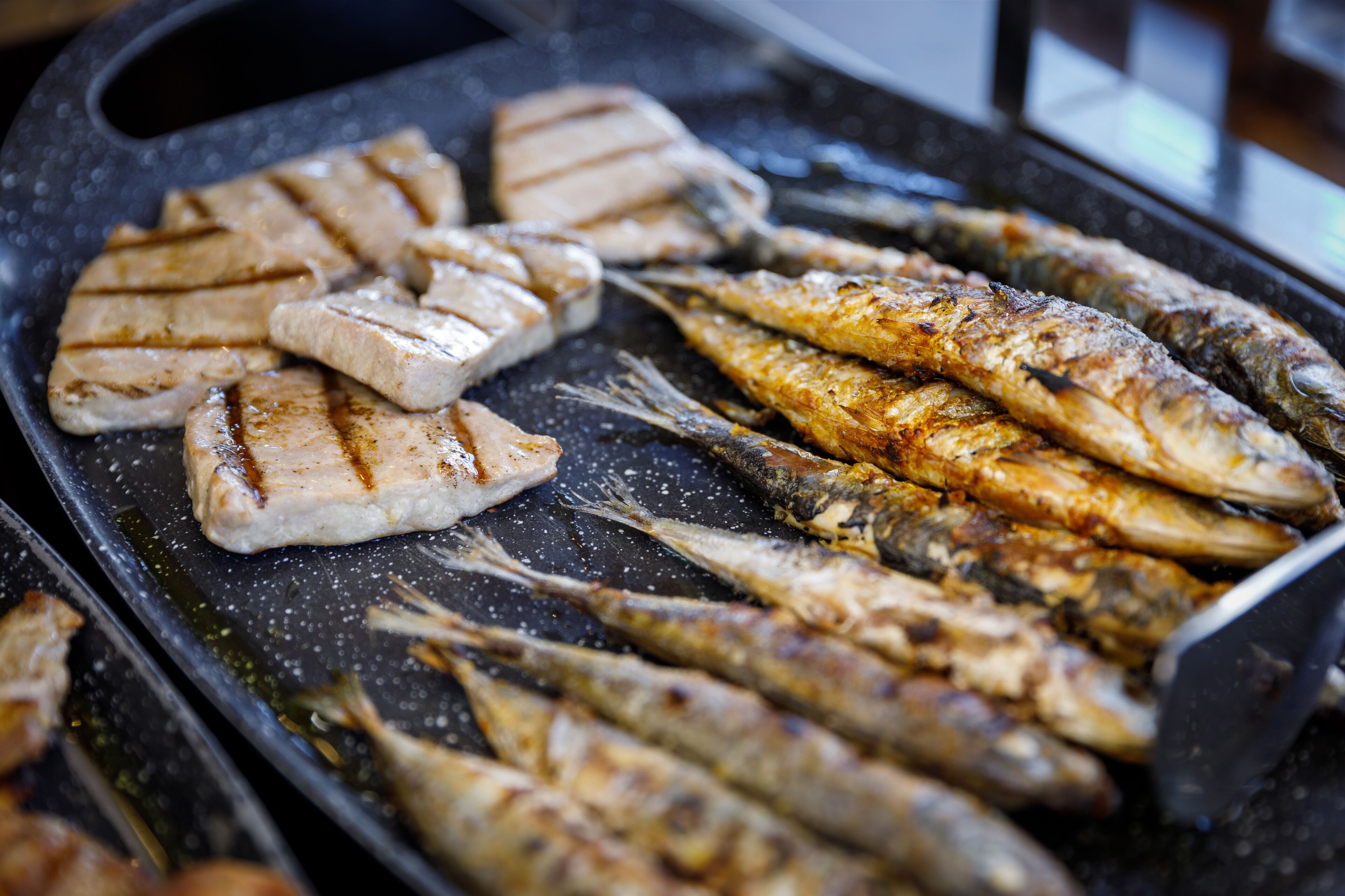 Grilled fish and chicken on a grill pan.