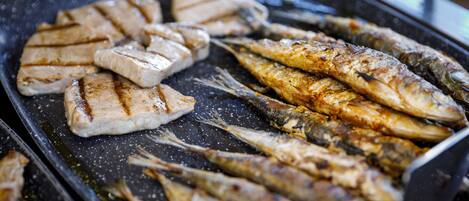 Grilled fish and chicken on a grill pan.