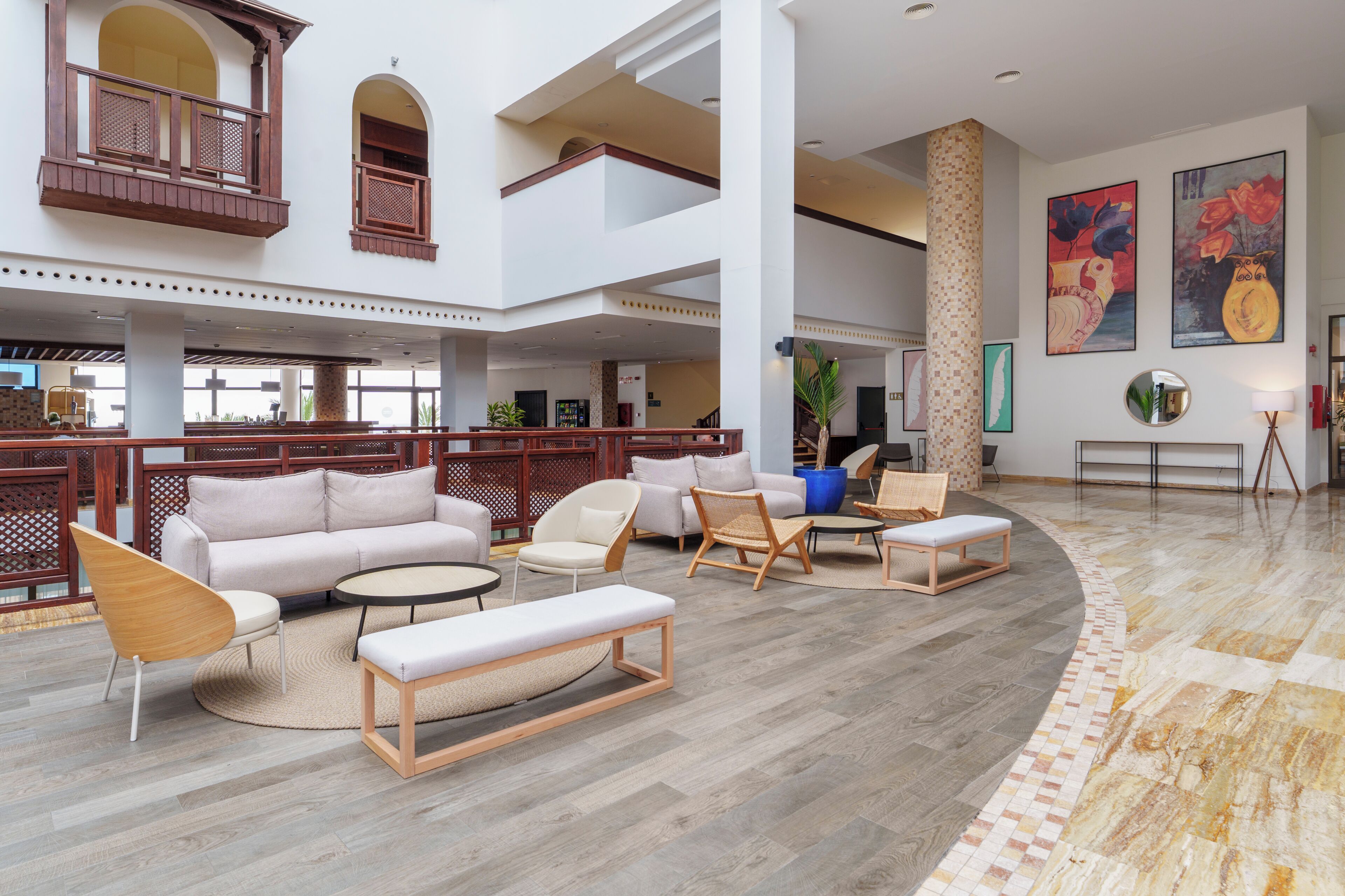 A spacious lobby with a high ceiling, multiple seating areas, and a central column.