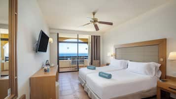 Camera d'albergo con un letto, una televisione, una scrivania e un balcone con vista.