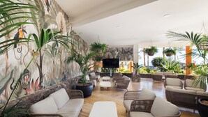 A spacious lounge with wicker furniture, a flat-screen TV, and a mural of tropical wildlife. - Occidental Jandía Playa (Pajara)