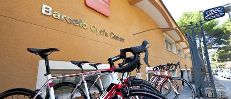 A building with a sign reading "Barceló Cycle Center" and several bicycles parked outside.