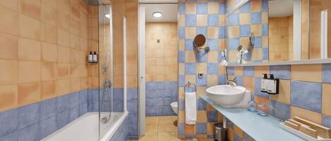 Ein modernes Badezimmer mit Badewanne, Dusche, Waschbecken und einem großen Spiegel.