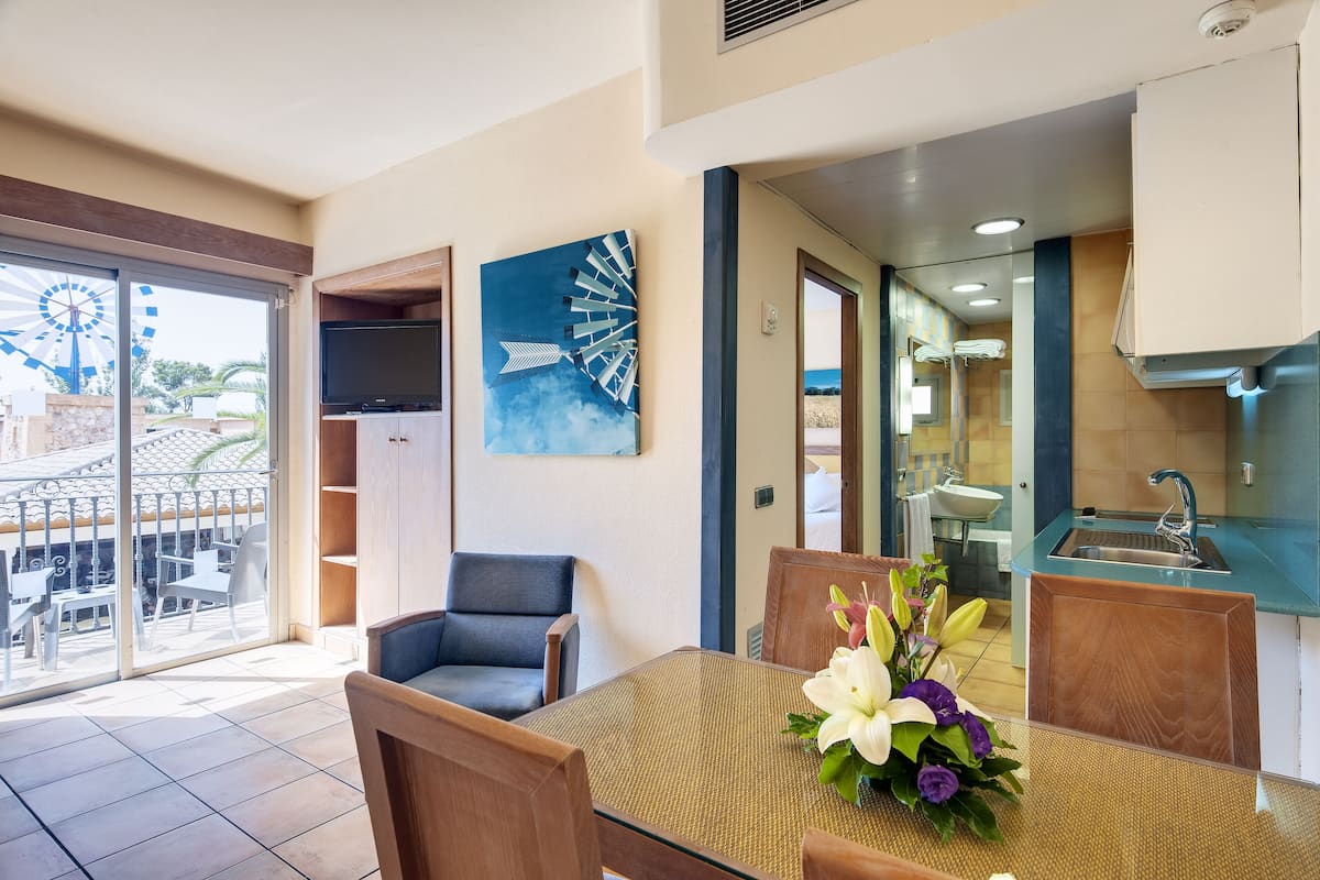 A dining area with a table, chairs, and a decorative flower arrangement.