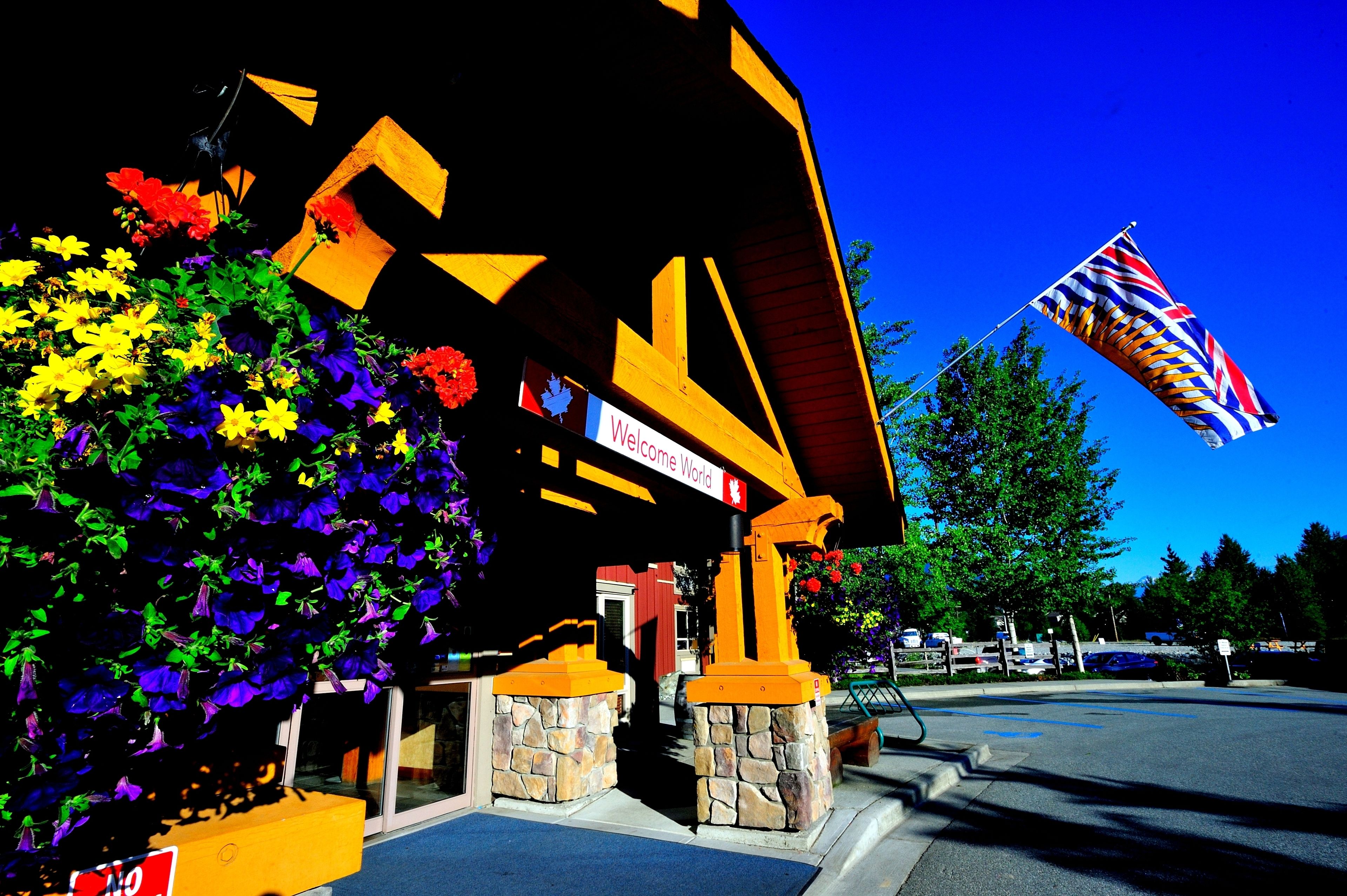 A building with a 'Welcome World' sign, stone pillars, and a flag.
