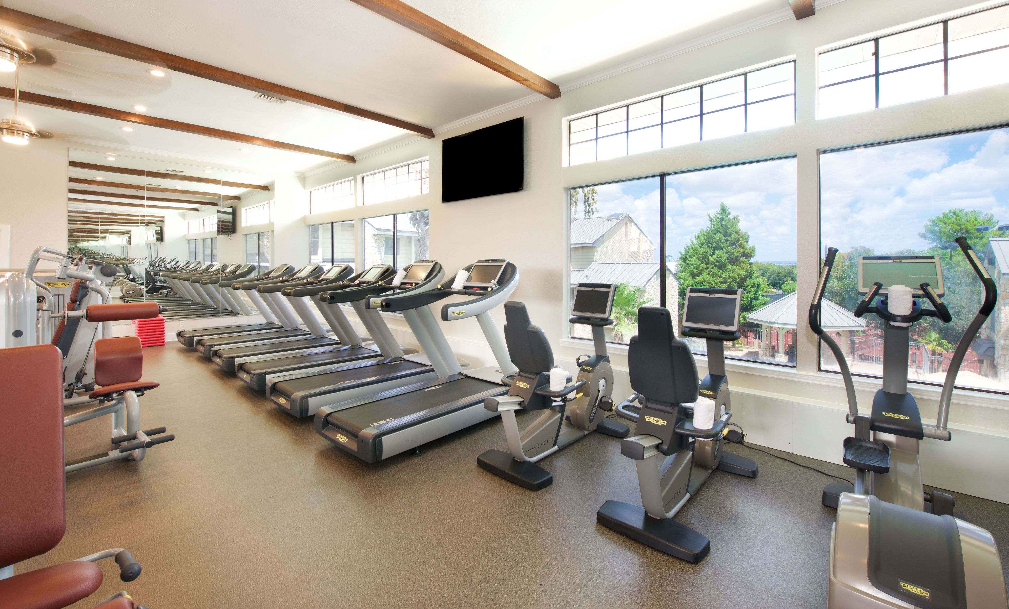 A gym with treadmills, ellipticals, and exercise equipment.