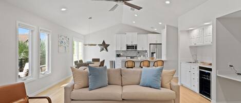 A modern living room with a beige sofa, a coffee table, and a ceiling fan.
