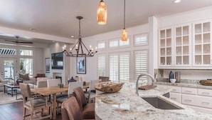 A spacious kitchen with a large island, white cabinetry, and a modern chandelier. - Horseshoe Bay Resort (Horseshoe Bay)