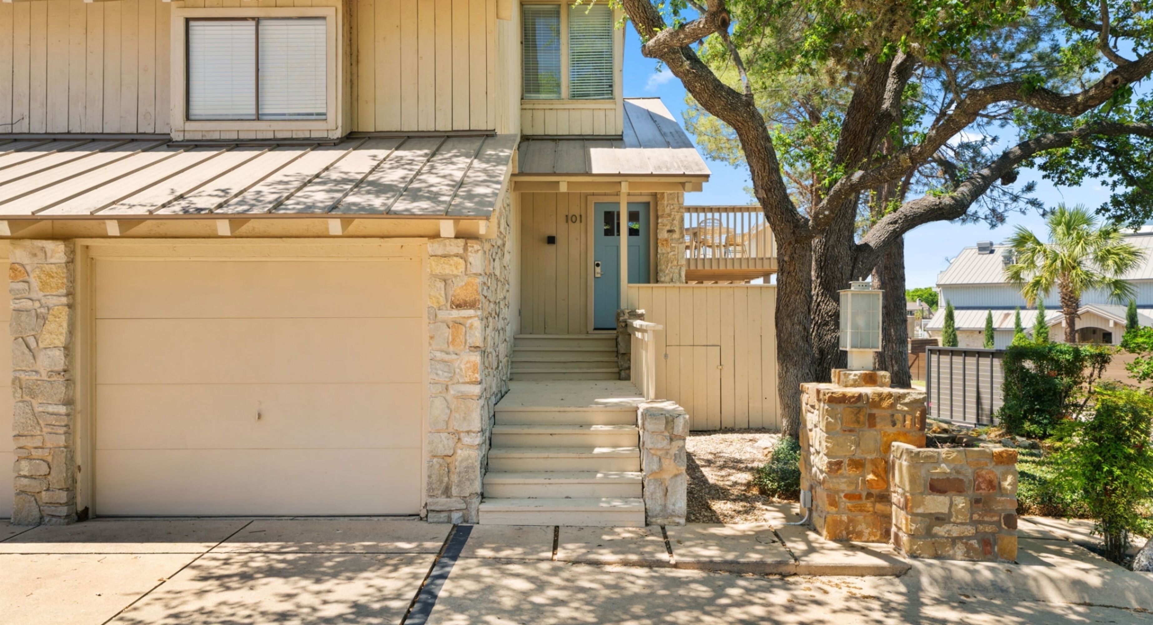 A two-story house with a stone facade, a garage, and a front porch.