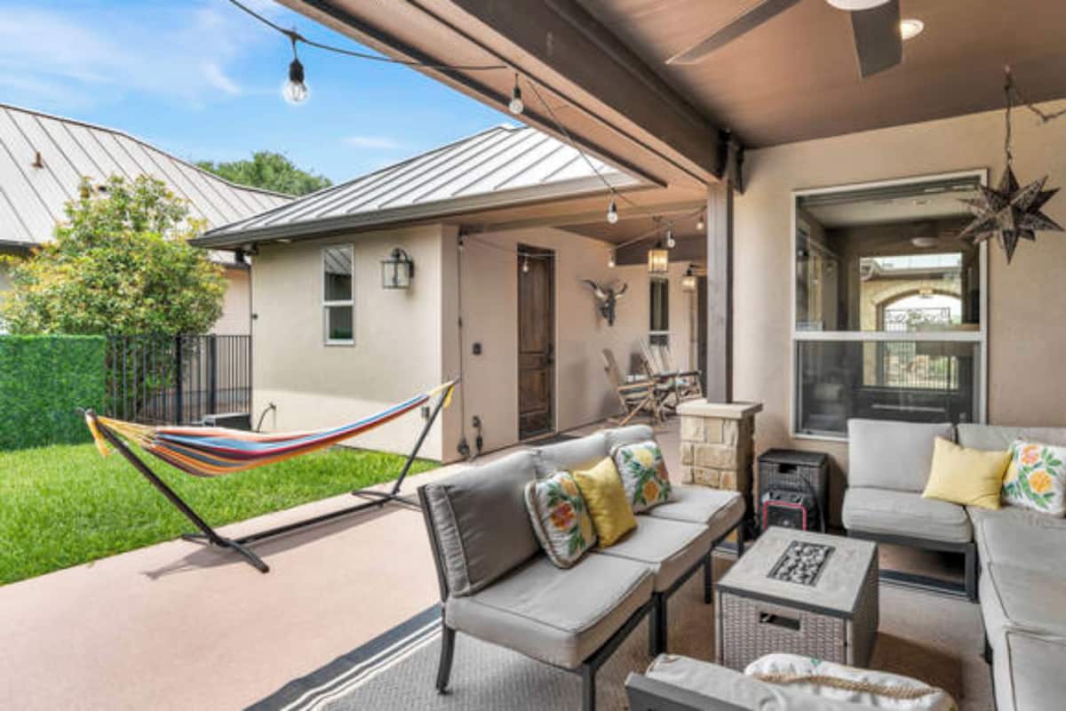 A covered patio area with outdoor furniture, a hammock, and a star decoration.