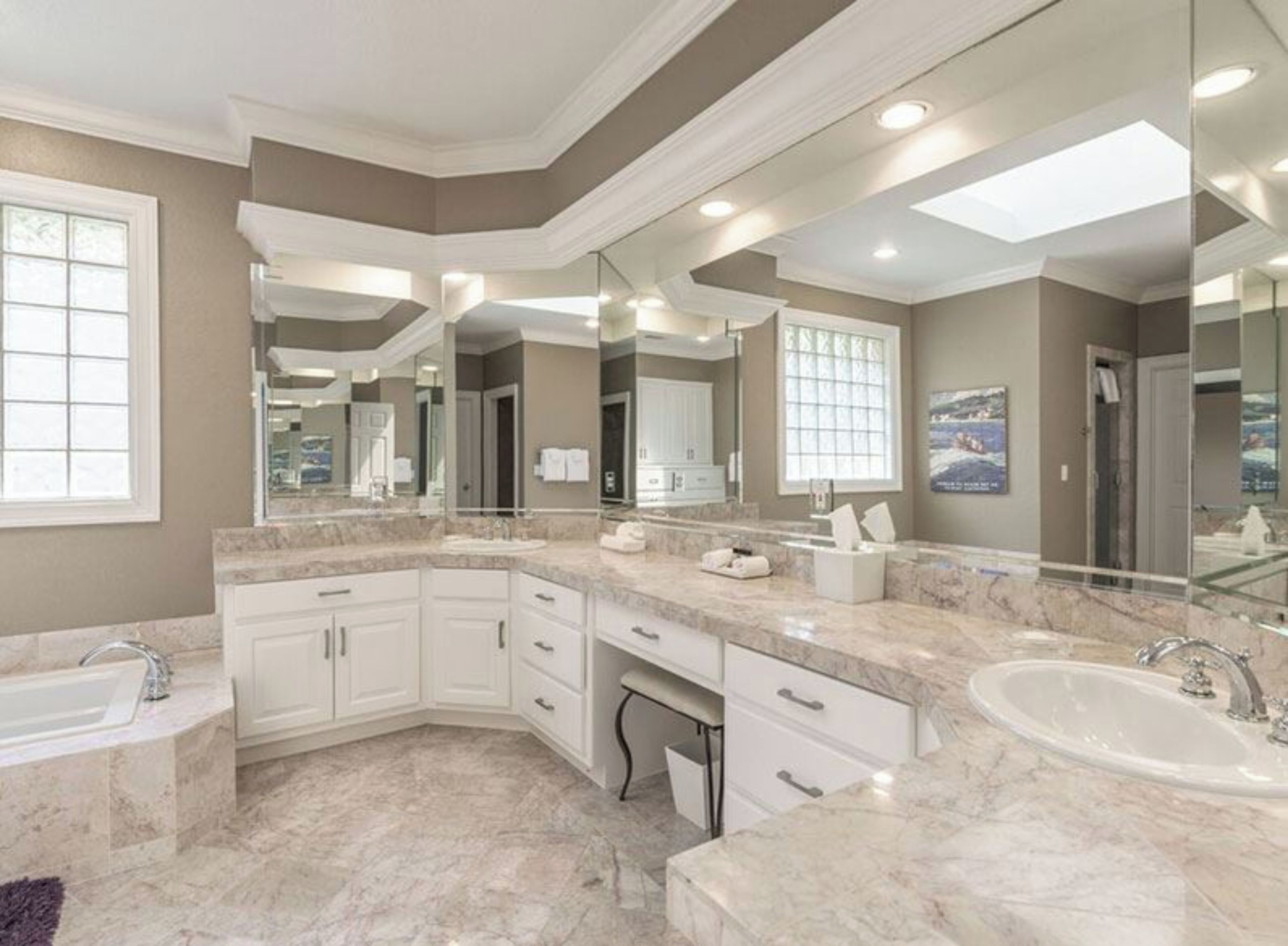 A modern bathroom with a curved vanity, a large mirror, and a walk-in shower.