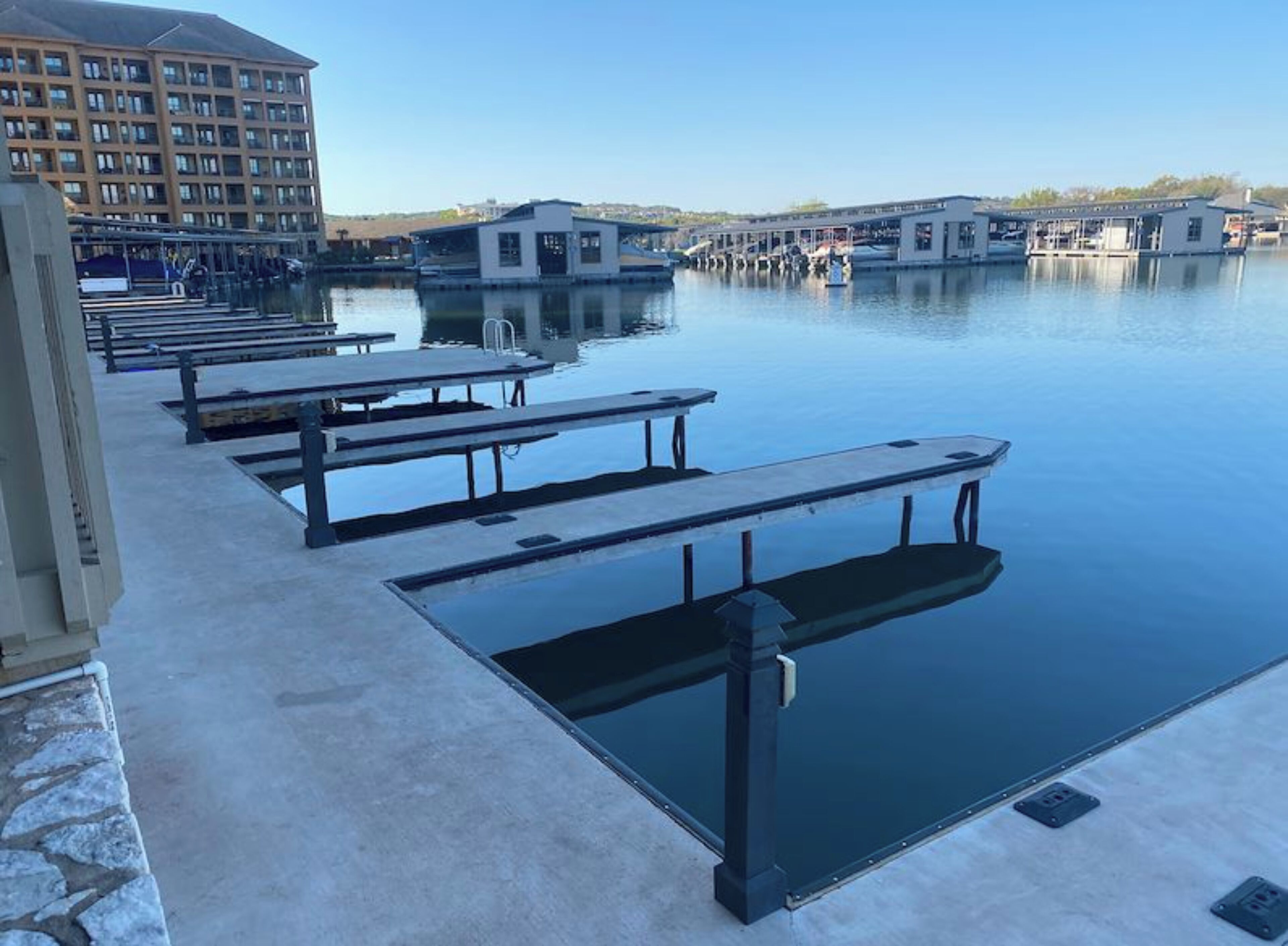 Una piscina con varias bancas y un edificio al fondo.