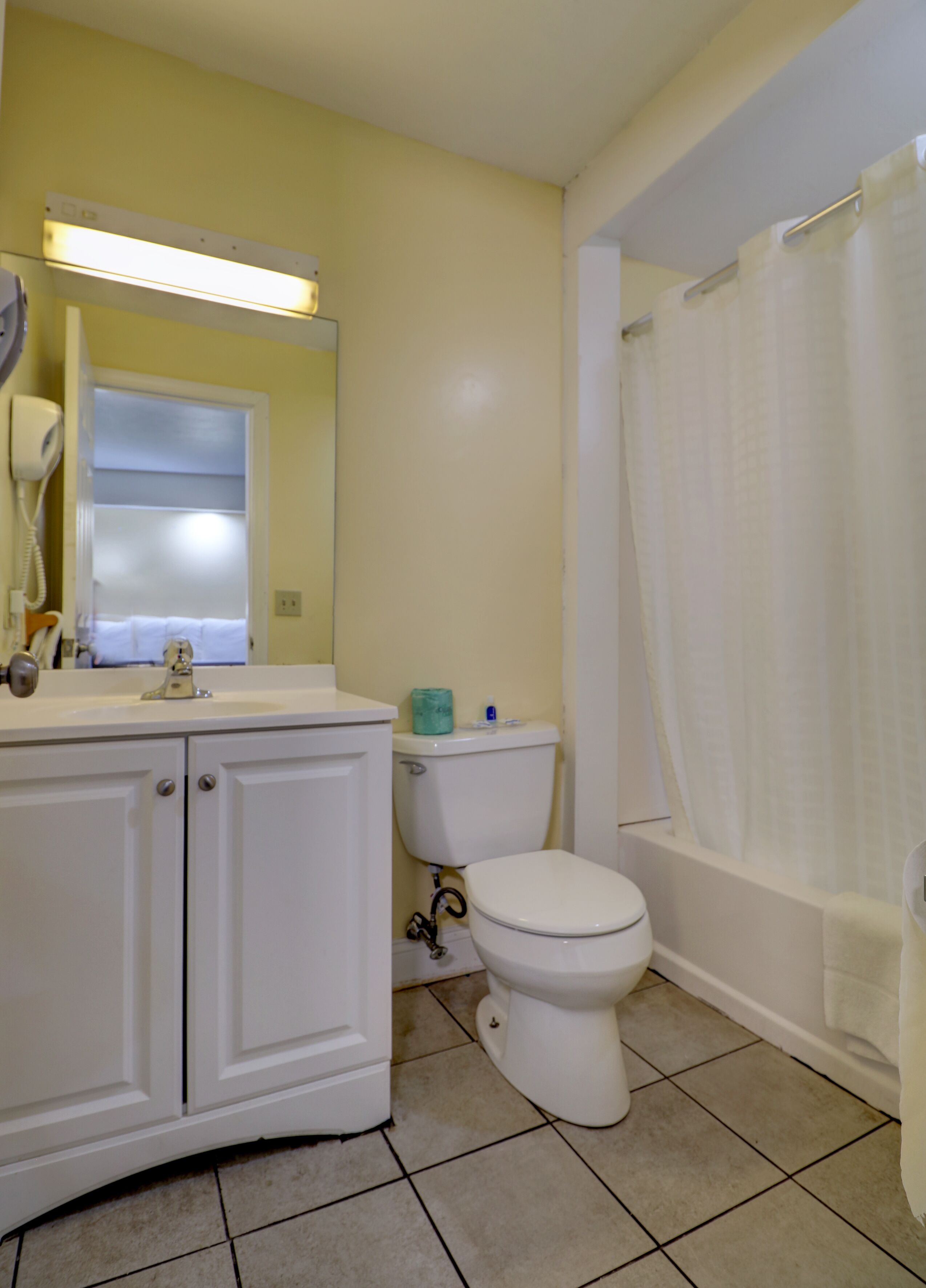 A bathroom with a toilet, sink, and shower curtain.