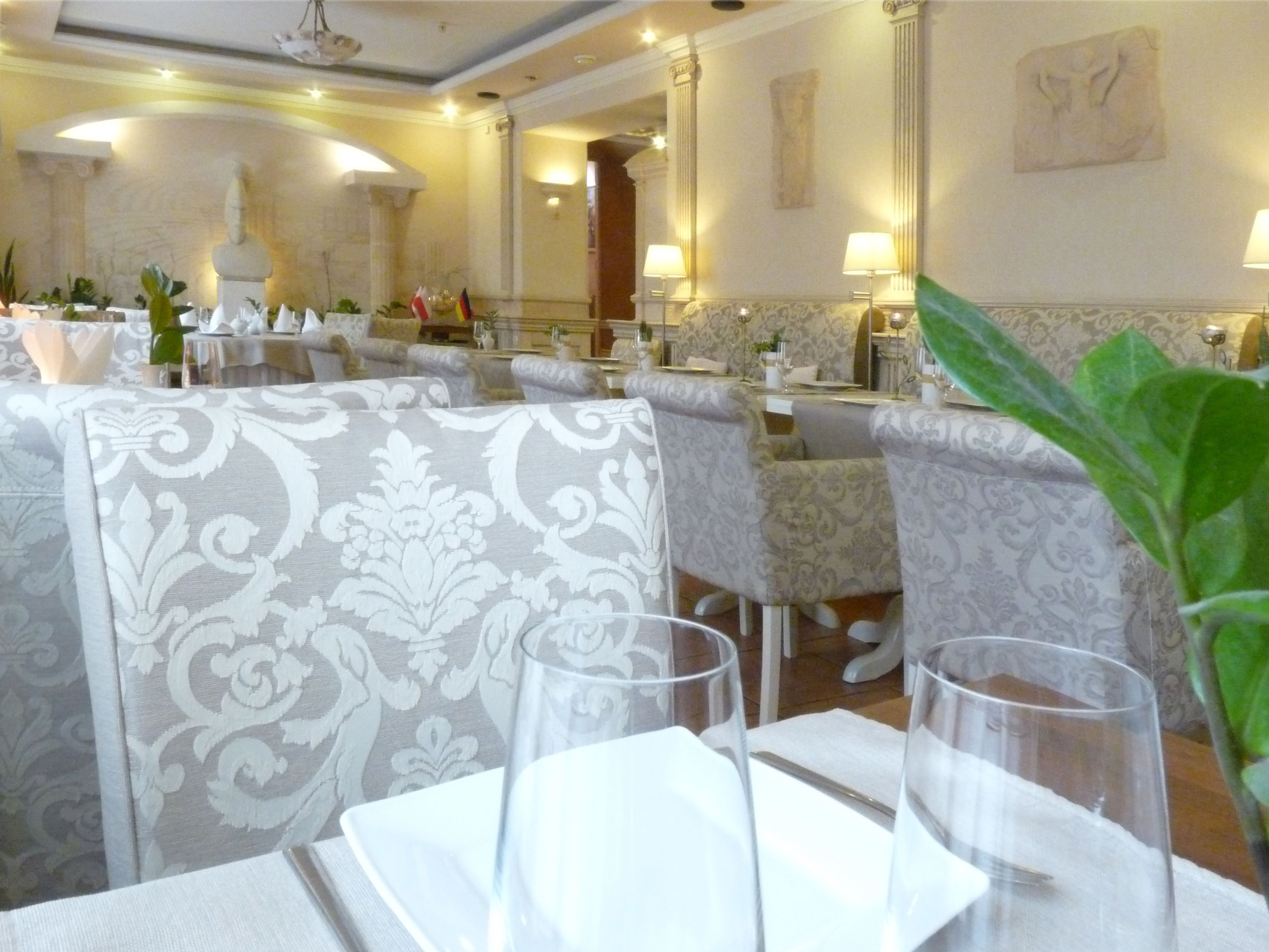 Ein Restaurant mit gedeckten Tischen, mit gemusterten Polstern und klassischer Inneneinrichtung.