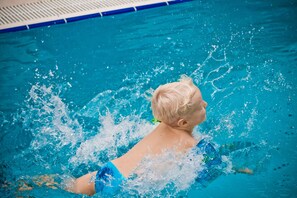 A child swimming in a pool with clear blue water.