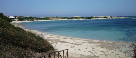 Una spiaggia nelle vicinanze, sabbia bianca, lettini da mare, ombrelloni