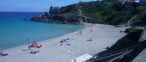 In Strandnähe, weißer Sandstrand, Liegestühle, Sonnenschirme