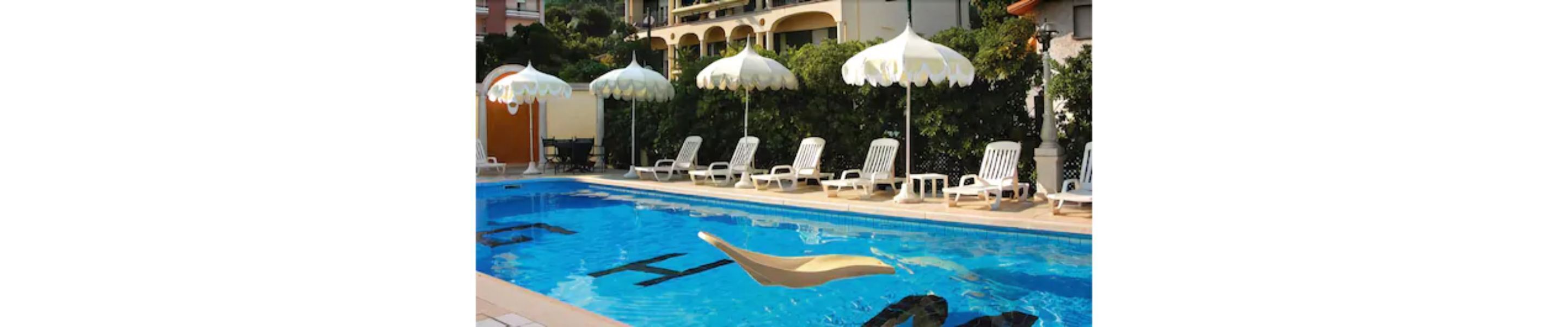A swimming pool with lounge chairs and umbrellas.