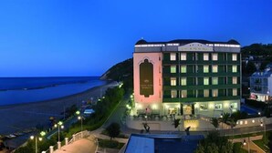 A hotel with a central courtyard, multiple floors, and a view of the beach. - Grand Hotel Michelacci (Gabicce Mare)