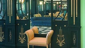 A luxurious room with a large mirror, a plush sofa, and a patterned floor. - Grand Hotel Michelacci (Gabicce Mare)