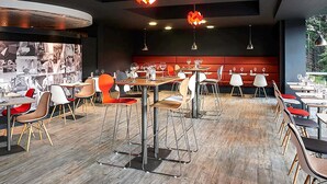 A modern restaurant interior with high tables, bar stools, and pendant lighting. - ibis Swansea (Swansea)
