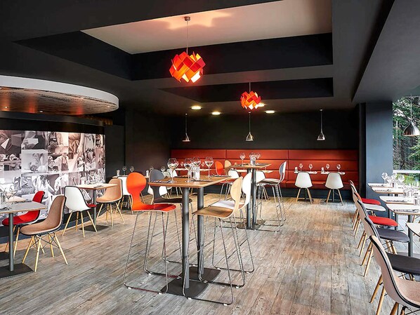 A modern restaurant interior with high tables, bar stools, and pendant lighting. - ibis Swansea (Swansea)