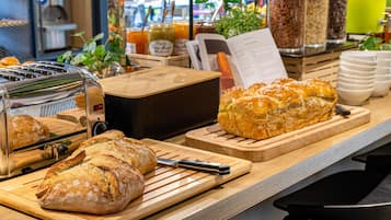 A breakfast buffet with bread, a toaster, and various food containers.