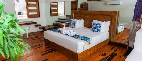A bedroom with a wooden bed, a large mirror, and a staircase leading to an upper level.