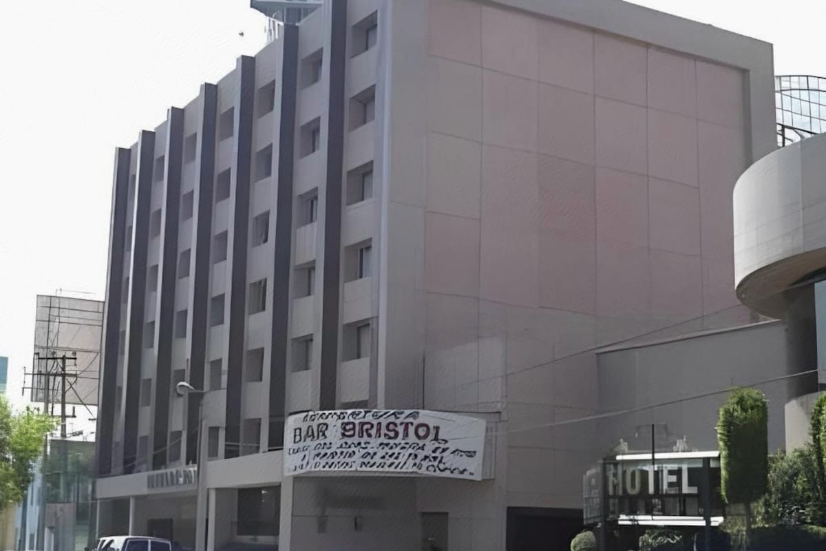 A multi-story building with a sign for 'HOTEL' and a banner for 'BAR BRISTOL' advertising a special offer.