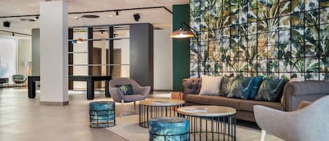 A modern lounge area with seating, a ceiling fan, and a decorative wall.