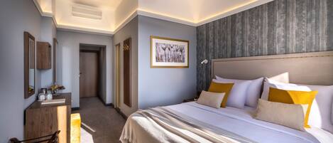Ein modernes Hotelzimmer mit einem großen Bett, einem Holztisch und einem gerahmten Bild an der Wand.