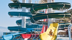 Een waterpark met meerdere glijbanen en een zwembad.