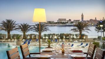 A table set for dining with a view of a marina and cityscape.