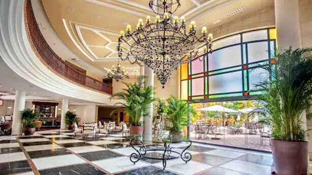 A spacious lobby with a checkered floor, a central chandelier, and potted plants. - Barceló Marbella (Marbella)