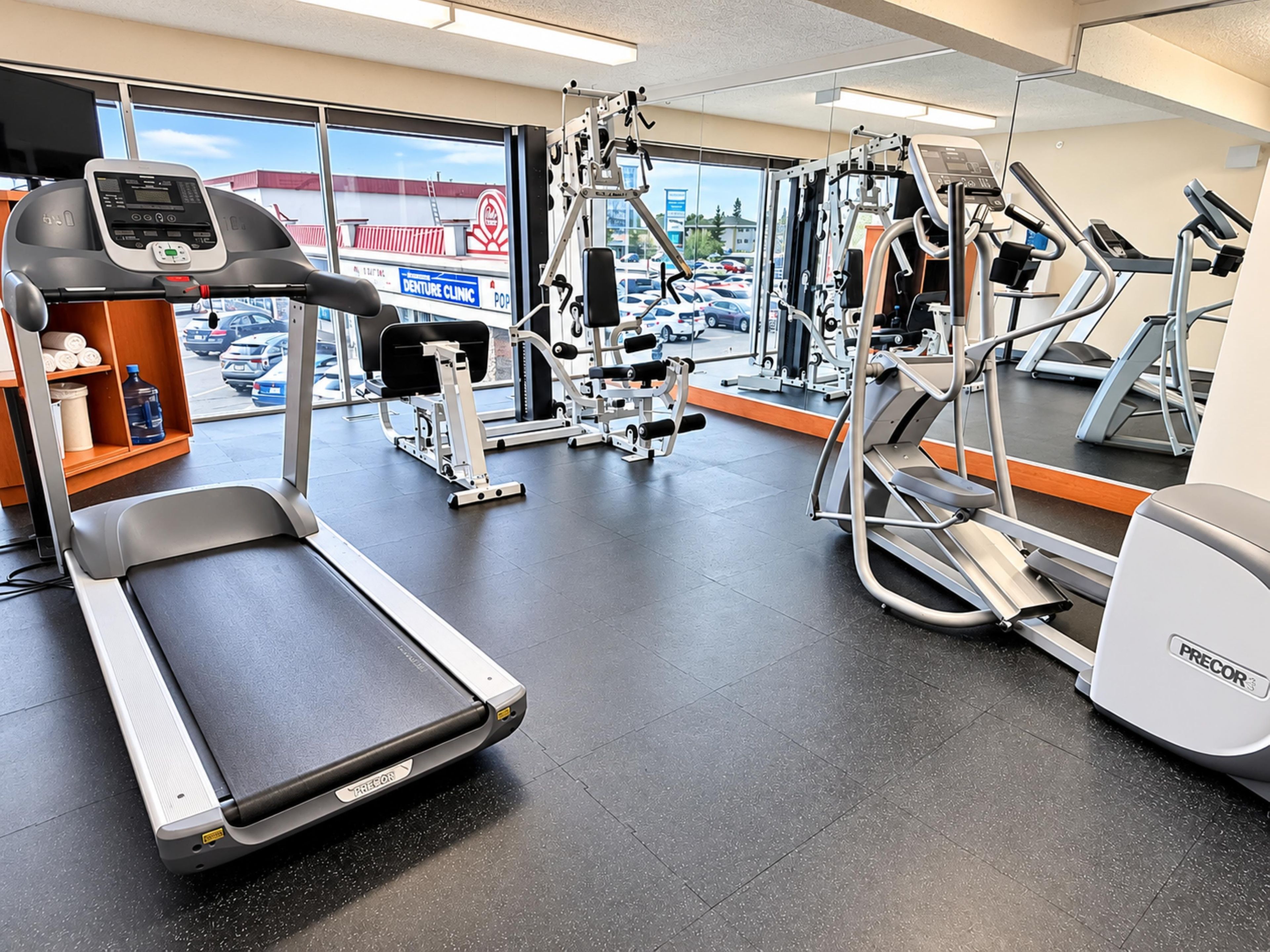 A gym with treadmills, weight machines, and a water cooler.