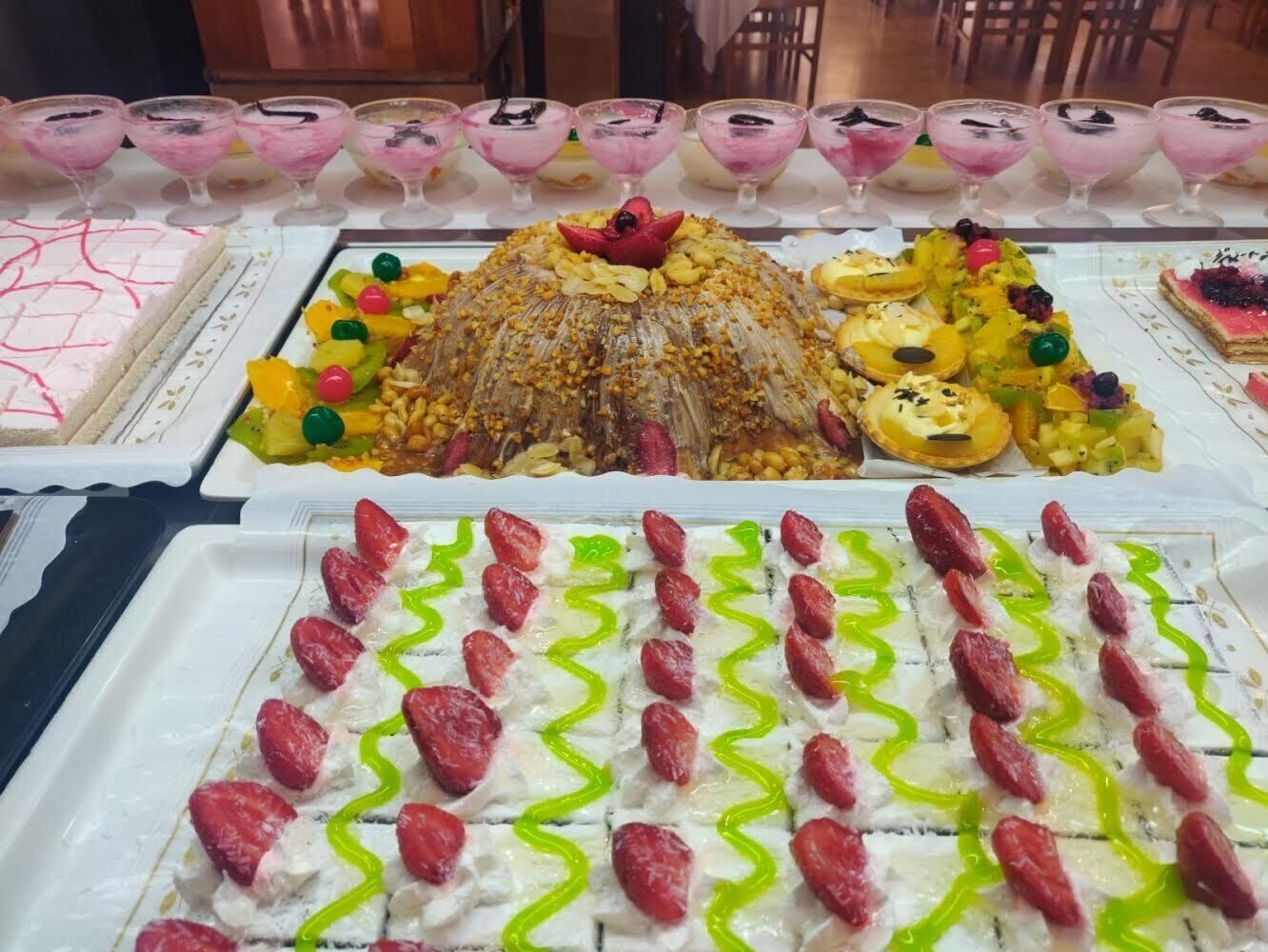 En dessertbuffet med forskellige søde sager og en kage.