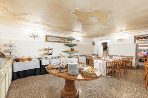 Un comedor con una barra de desayuno buffet, que incluye una variedad de alimentos y una lámpara decorativa.