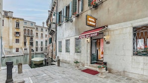 A canal-side hotel with a red awning and a sign reading "HOTEL SAN MOISE". - Hotel San Moisè (Venice)
