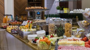 Ein Buffet mit verschiedenen Speisen, darunter Obst, Gemüse und Fleisch.