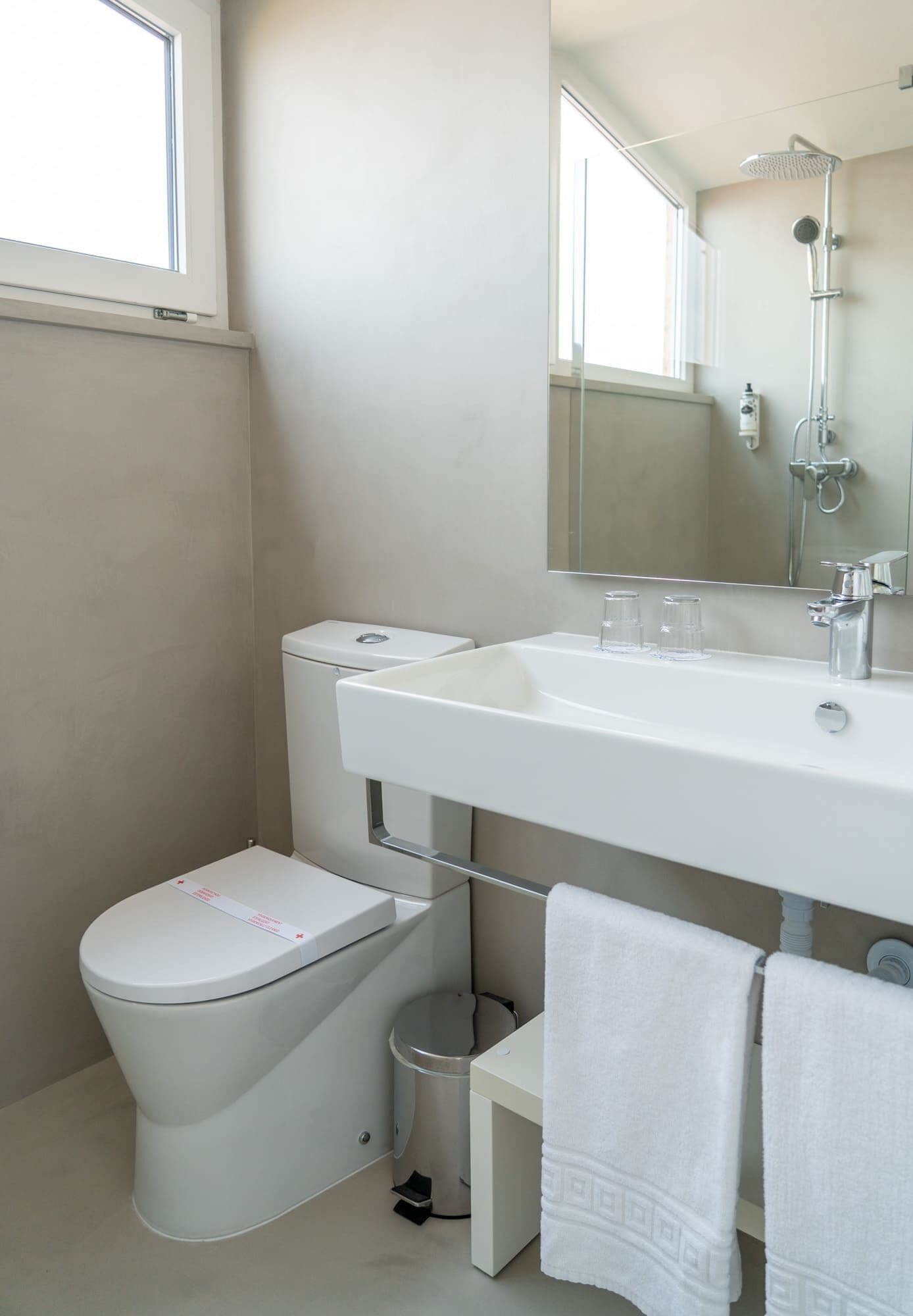 A modern bathroom with a toilet, sink, and shower.