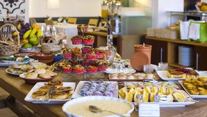 A buffet table with various food items and a sign indicating the breakfast menu. - Costa D’Oiro Ambiance Village (Lagos)