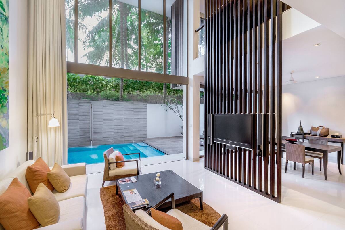 Un salon moderne avec vue sur la piscine, un coin repas et un téléviseur.