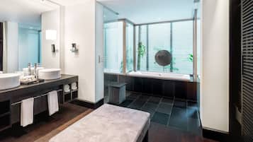 Un baño moderno con dos lavamanos, un espejo grande y una bañera.