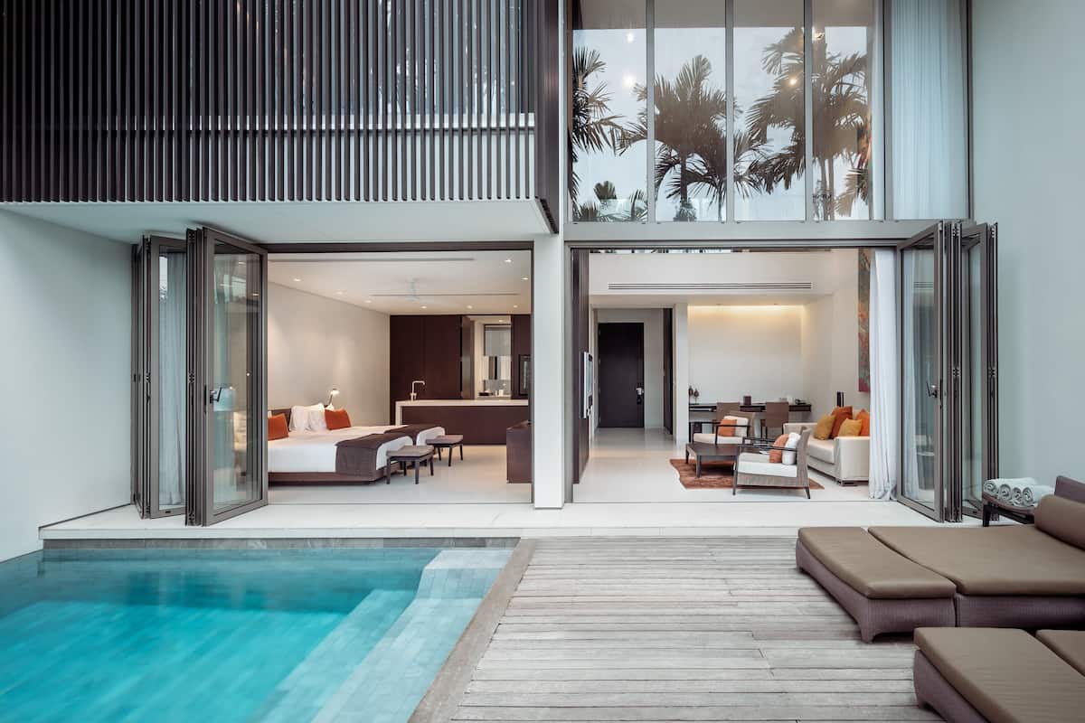Une maison moderne à deux étages, dotée d’un espace de vie à aire ouverte, d’une cuisine et d’un balcon avec piscine.