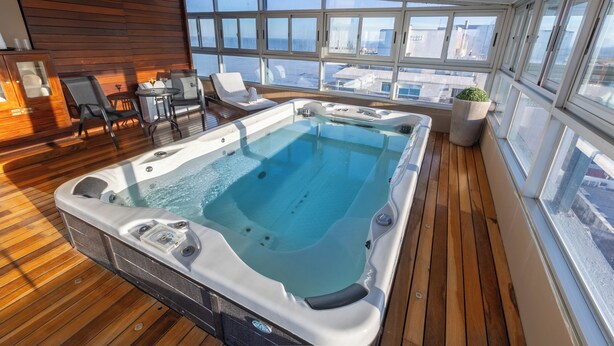 Un jacuzzi en una terraza de madera con vista a la ciudad.